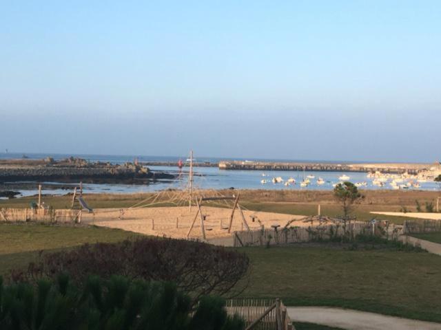 een strand met een schommel en het water bij APPART-STUDIOS VUE MER PANORAMIQUE ST GUENOLE Côté Mer in Penmarcʼh