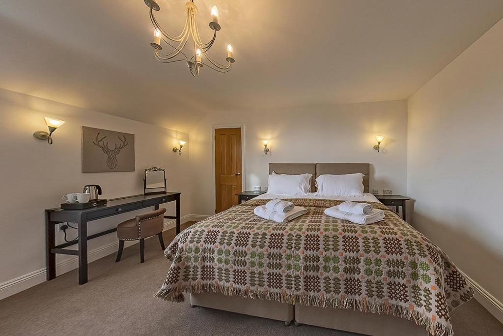 a bedroom with a bed with a desk and a bed sidx sidx sidx at 3 Bedroom Barn Conversion with HOT TUB-Garden View - Ty Cerrig Barn in Corwen