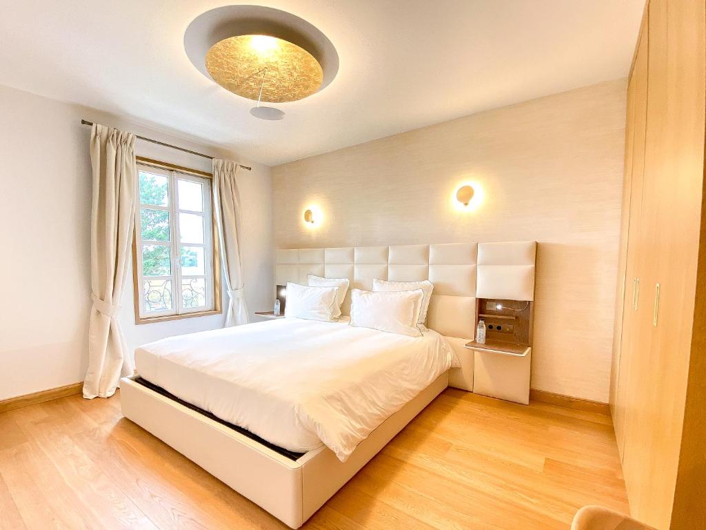 a bedroom with a white bed and a window at Petit Monlot - Saint-Emilion in Saint-Émilion