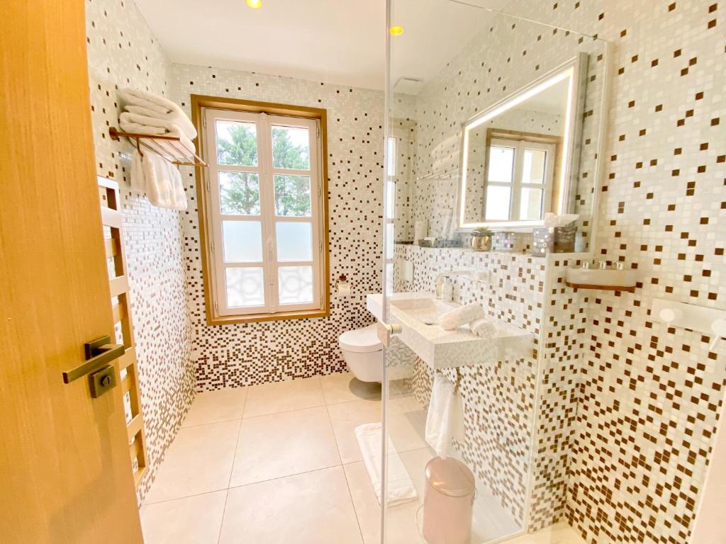 a bathroom with a toilet and a sink and a mirror at Petit Monlot - Saint-Emilion in Saint-Émilion