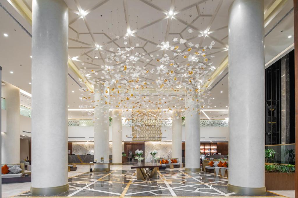 a lobby with a large chandelier in a hotel at Wirgan Hotel Al Azizyah in Makkah