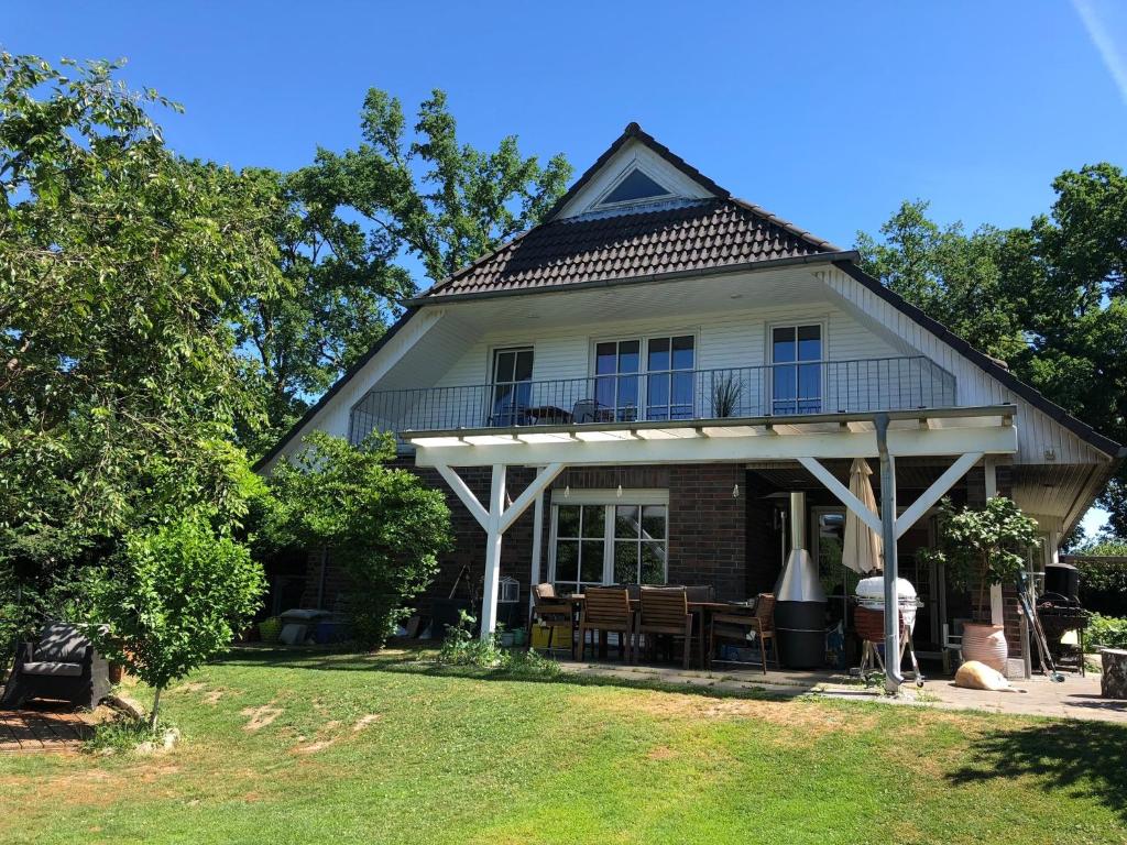 een groot wit huis met een gambrel dak bij Charmante 2-Zimmer Wohnung in Hoisdorf