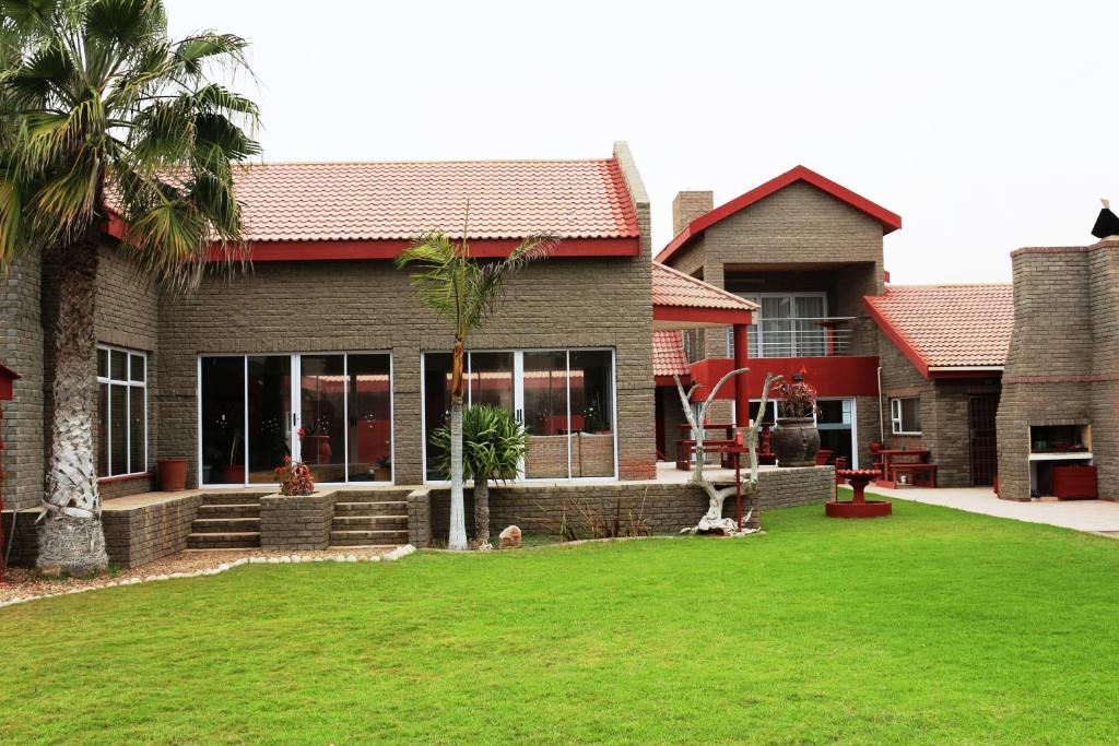 a house with a lawn in front of it at Amjicaja Guesthouse, Tours & Rentals in Walvis Bay