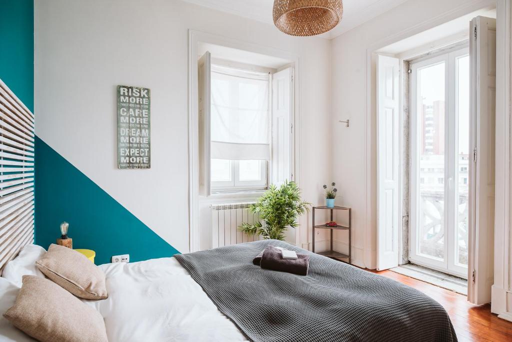 a bedroom with a bed and a large window at The Salty Pelican Beach Retreat in Monte Estoril