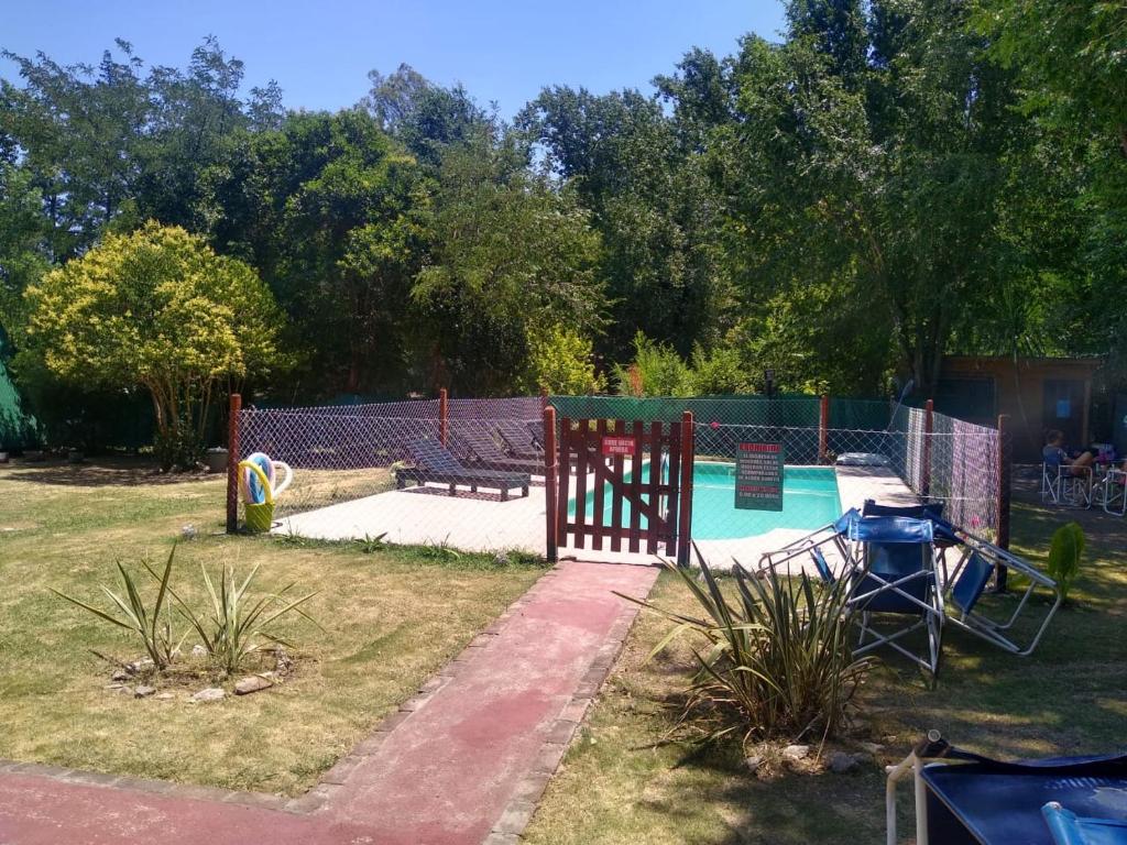 un patio trasero con piscina y parque infantil en Hotel Gran Córdoba en La Falda