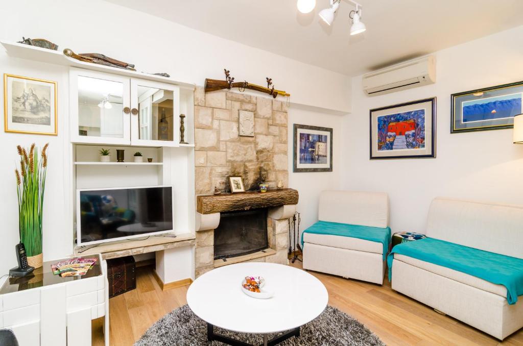 a living room with a fireplace and a tv at Holiday Home Tezoro Royal in Dubrovnik