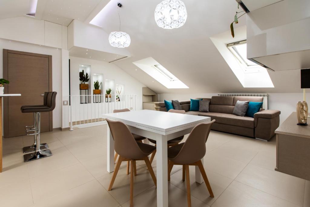 een keuken en een woonkamer met een witte tafel en stoelen bij Diamond apartment Agerola in Agerola