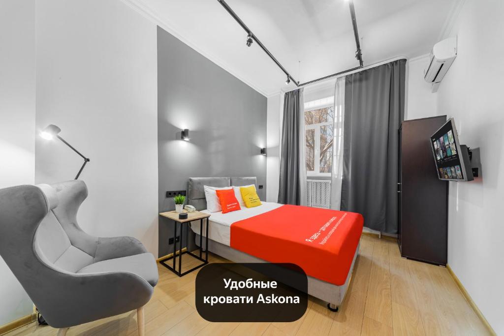 モスクワにあるミニマ ディナモのベッドルーム(ベッド1台、椅子、テレビ付)