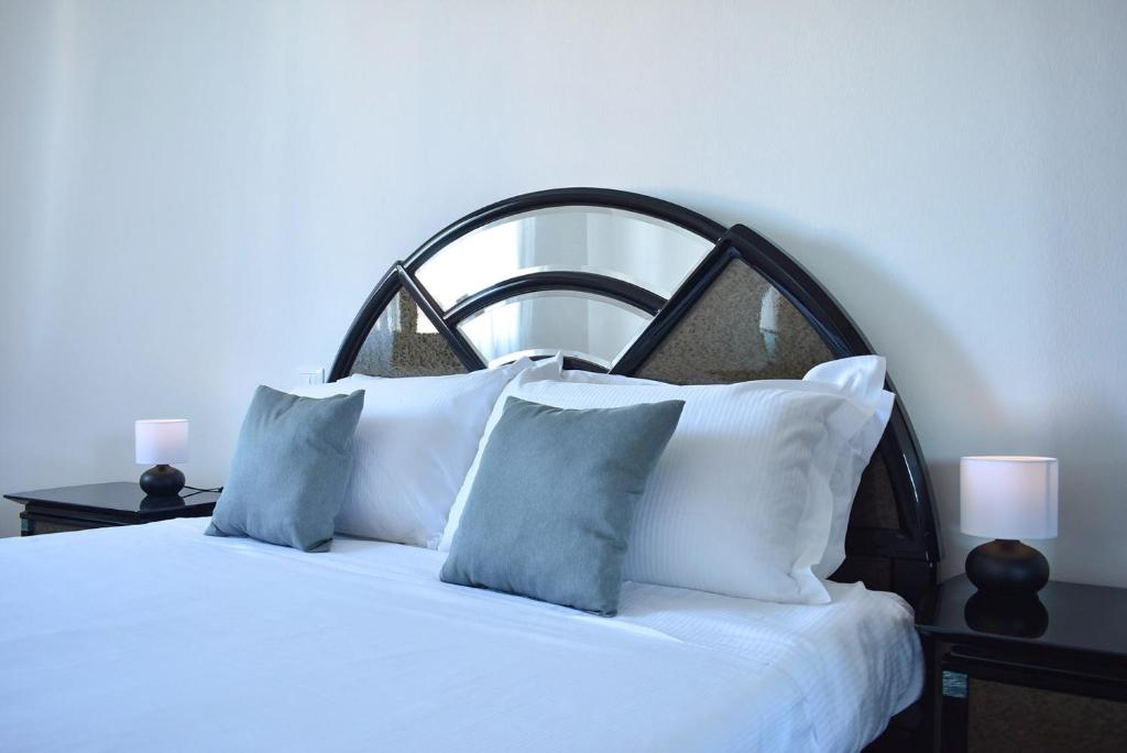 ein Schlafzimmer mit einem weißen Bett mit blauen Kissen in der Unterkunft By the Hills Apartment in Montegrotto Terme