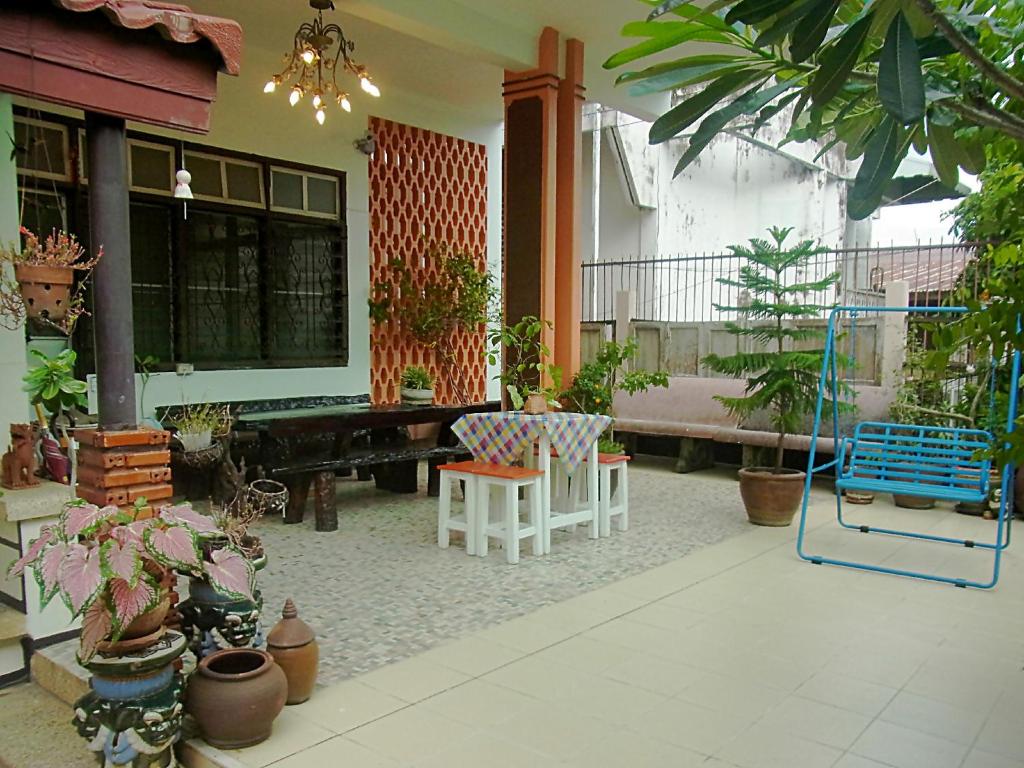 eine Terrasse mit einem Tisch, Stühlen und Pflanzen in der Unterkunft 28 Rachabutr Hostel in Ubon Ratchathani