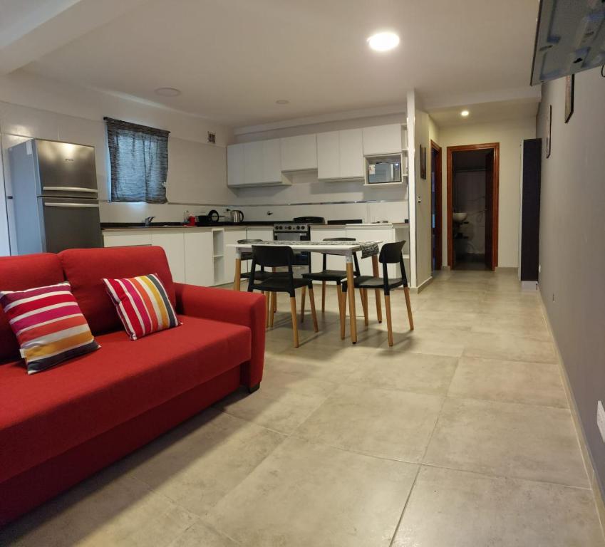 een woonkamer met een rode bank en een keuken bij Departamento Mara Bariloche in Bariloche