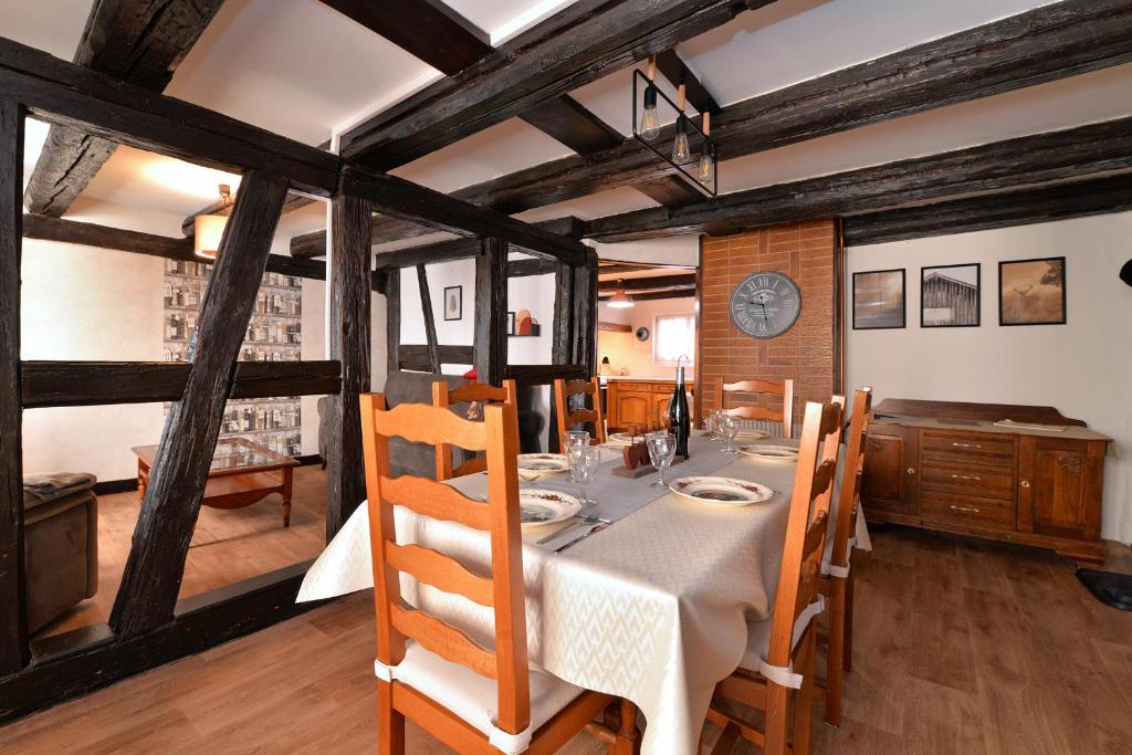 una sala da pranzo con tavolo, sedie e orologio di Chez Mamema, maison Alsacienne route des vins a Kintzheim