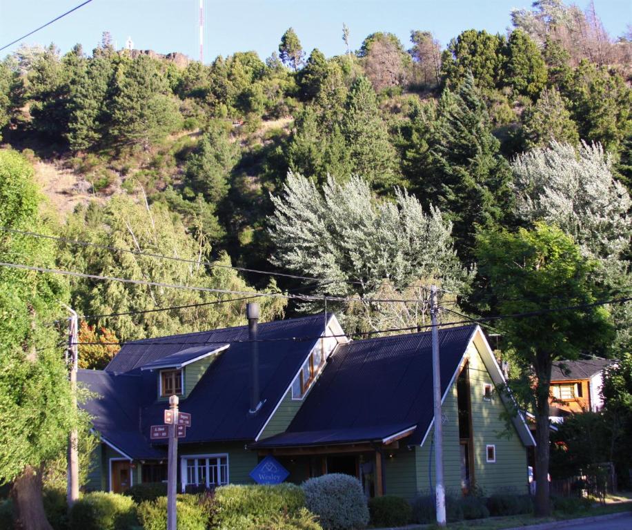 una casa con techo azul frente a una montaña en Wesley House en San Martín de los Andes