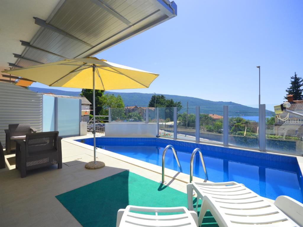 uma piscina com cadeiras e um guarda-sol amarelo em TOP-APARTMENT MONTENEGRO, with private Pool! em Kumbor