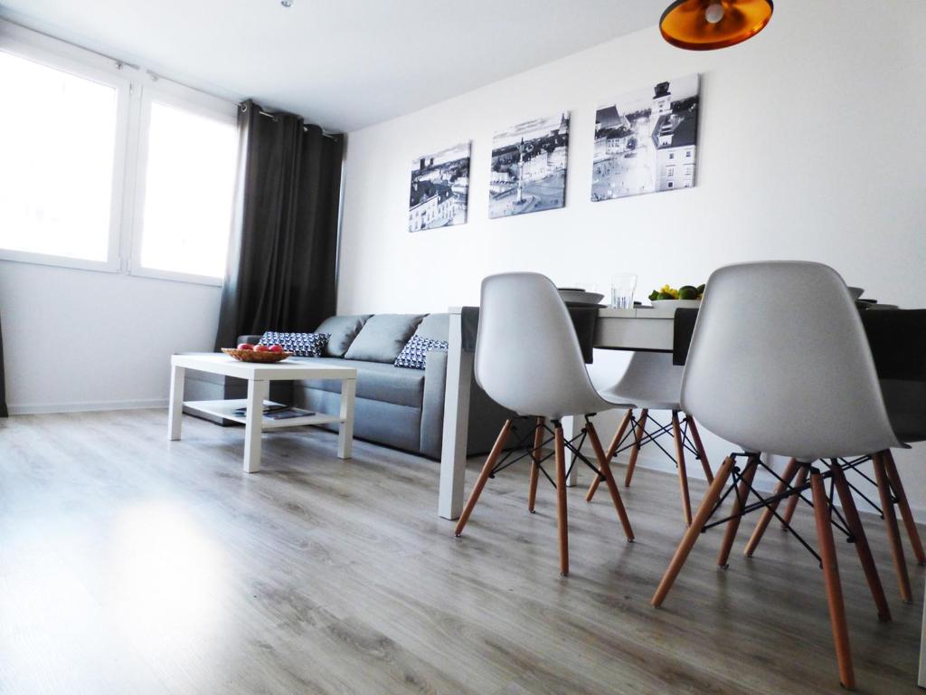 ein Wohnzimmer mit 2 Stühlen und einem Tisch in der Unterkunft Plac Grzybowski Apartment in Warschau