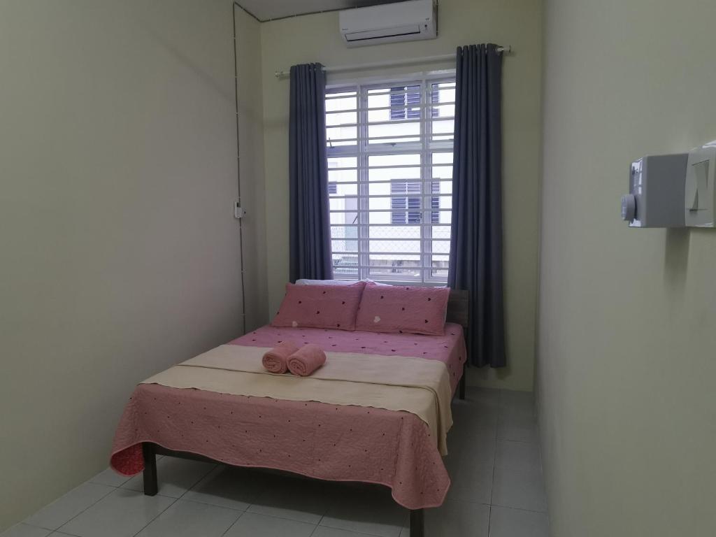 ein kleines Bett in einem Zimmer mit Fenster in der Unterkunft Padang Besar Homestay in Padang Besar
