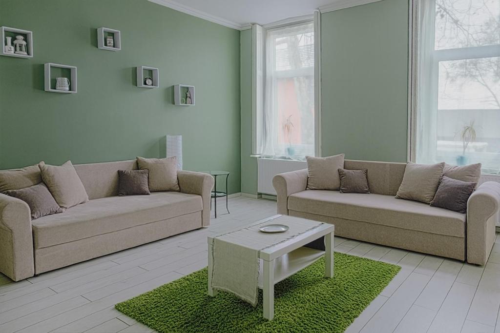 a living room with two couches and a table at HEMNES Apartman in Kaposvár
