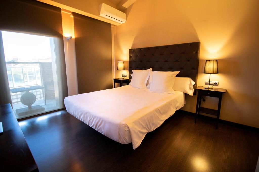 ein Schlafzimmer mit einem großen Bett und einem großen Fenster in der Unterkunft Hotel Alda Castillo de Olite in Olite