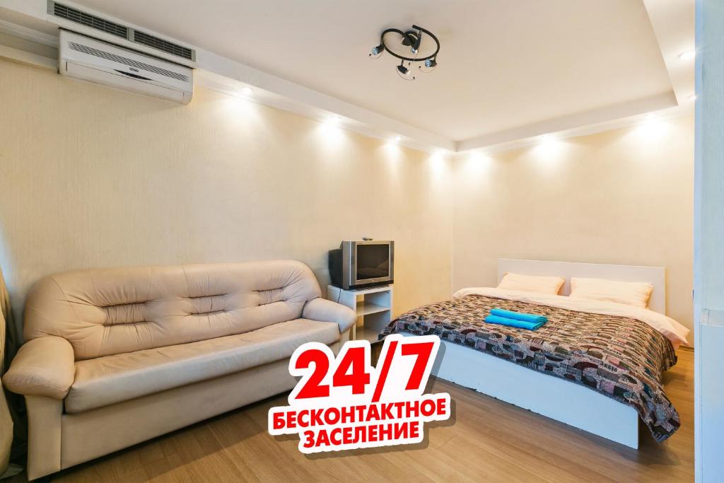 モスクワにあるMaxRealty24 Leningradskij prospekt 33Aのベッドルーム(ベッド1台、ソファ、テレビ付)