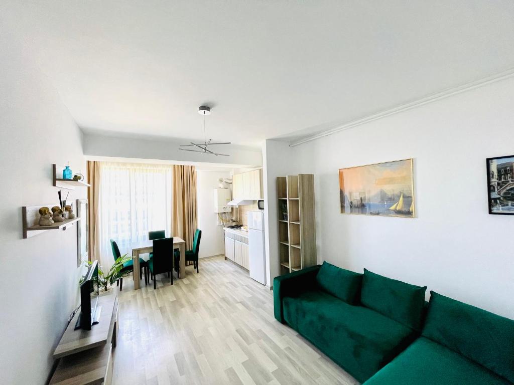 a living room with a green couch and a table at Summerland Studios Nuba in Mamaia