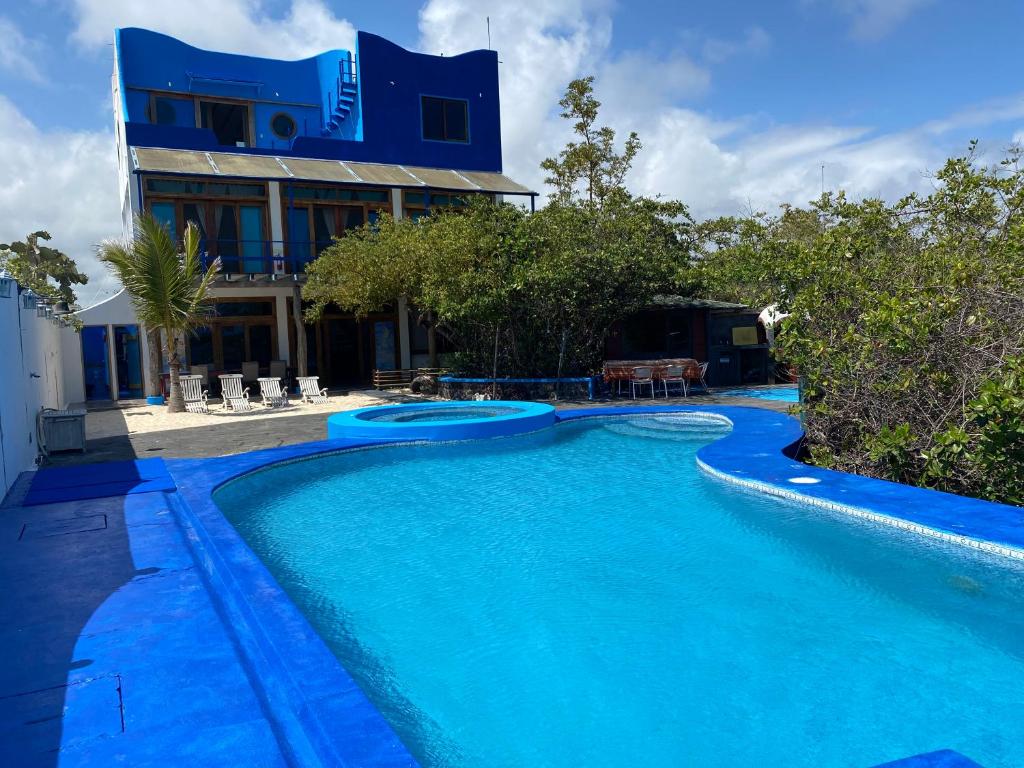 a swimming pool with blue water in front of a building at Bay House in Puerto Ayora