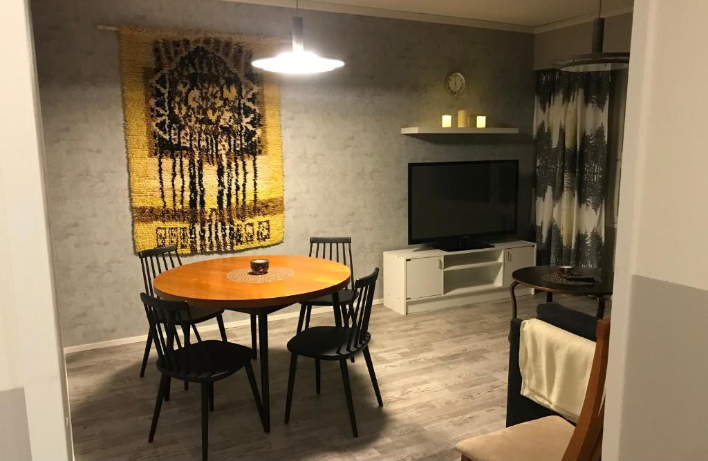 a dining room with a table and chairs and a television at Villa Vankka in Pohjaslahti