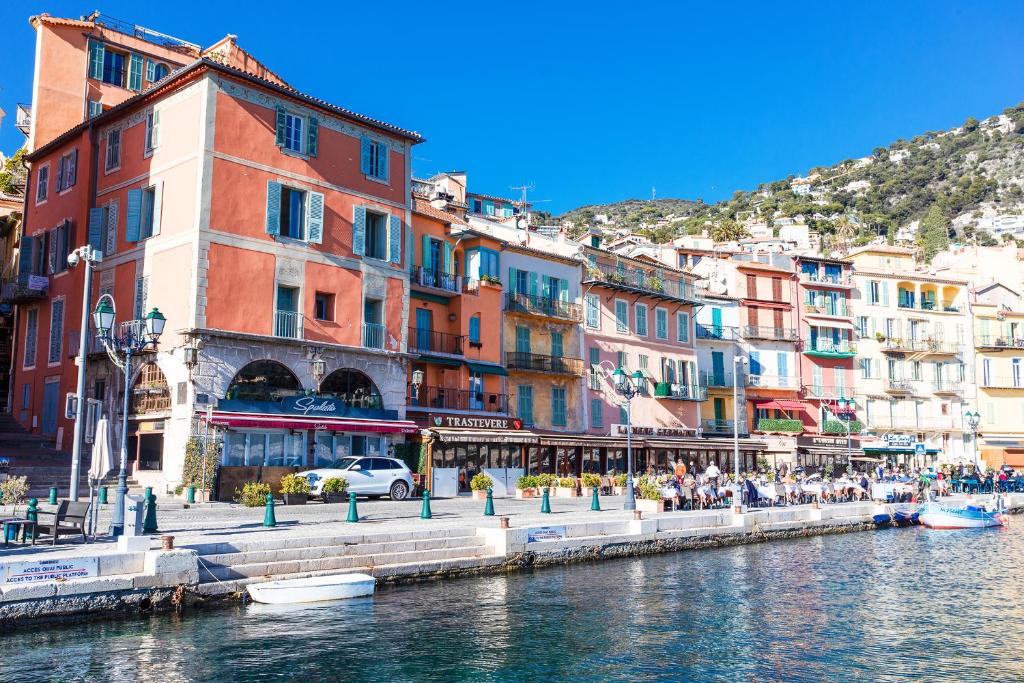 um grupo de edifícios ao lado de uma massa de água em ON VILLEFRANCHE BAY - AP3040 by Riviera Holiday Homes em Villefranche-sur-Mer