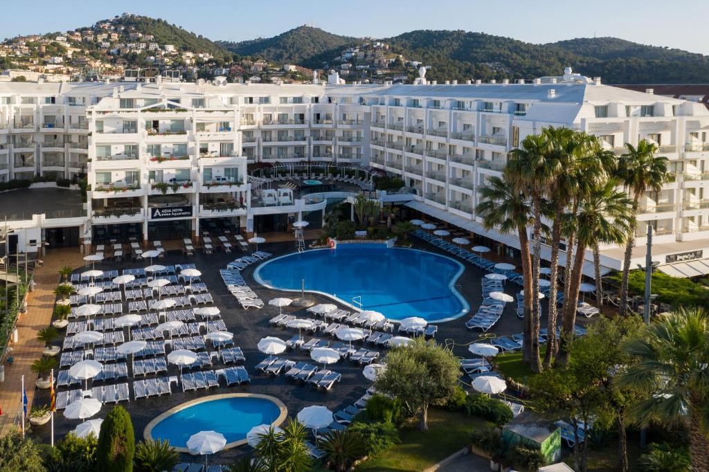 eine Luftansicht eines Resorts mit Pool und Sonnenschirmen in der Unterkunft AQUA Hotel Aquamarina & Spa in Santa Susanna