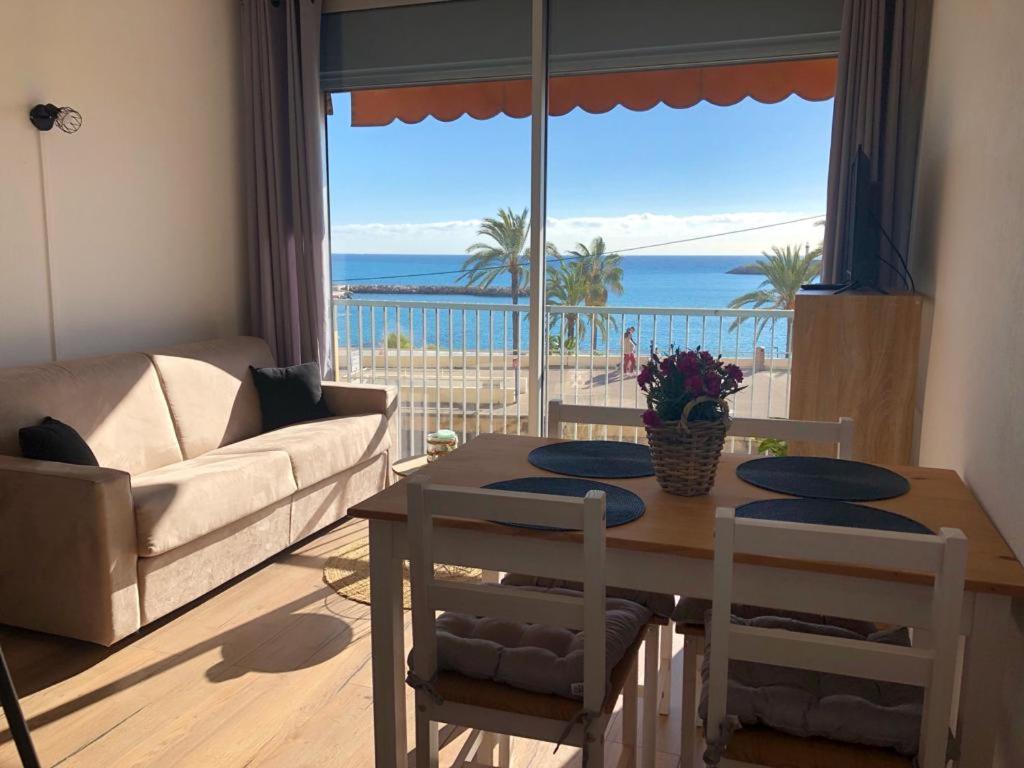 Sala de estar con mesa y vistas al océano en Studio front de mer - Menton Garavan, en Menton