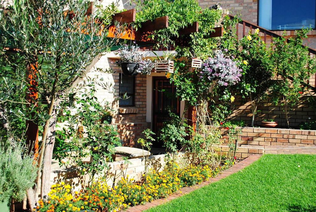 a garden with flowers in front of a house at Remini in Jeffreys Bay