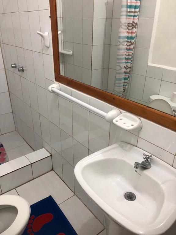 y baño con lavabo, espejo y aseo. en Hostal Marysol, en Puerto Ayora