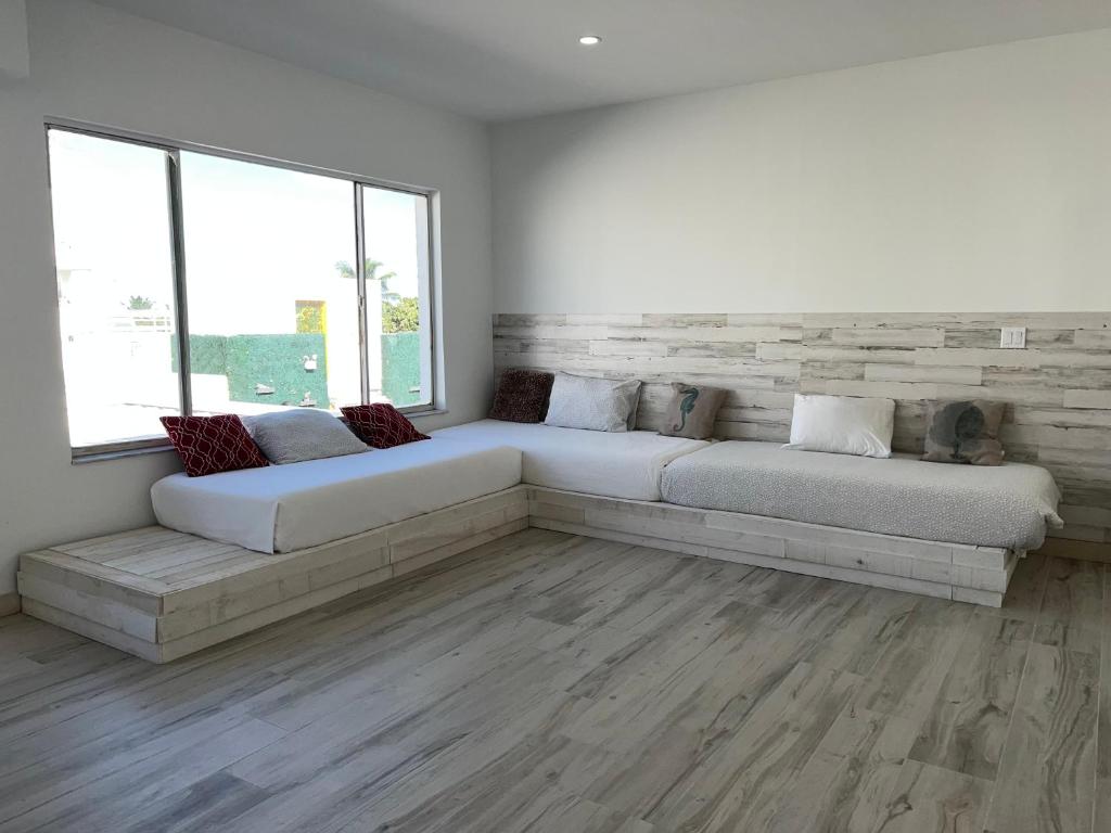 una sala de estar con 2 camas en una habitación con ventanas en SOBE suites in Miami Beach en Miami Beach