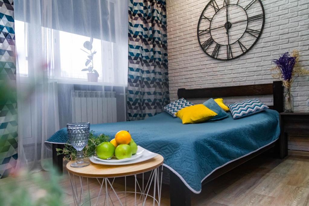 Schlafzimmer mit einem Bett und einem Obstteller auf dem Tisch in der Unterkunft Weekend in Krasnojarsk