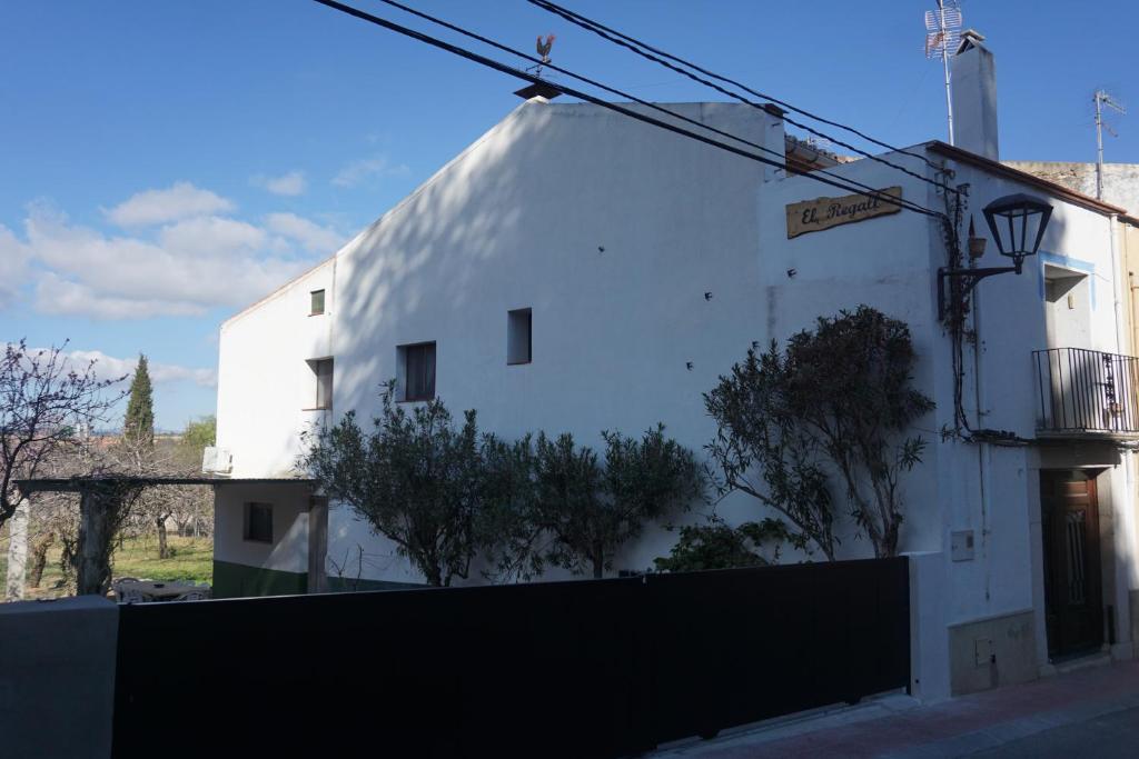 un bâtiment blanc sur le côté d'une rue dans l'établissement Casa El Regall, à Cálig