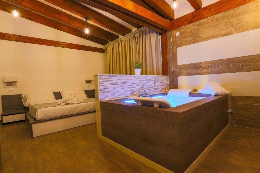 uma casa de banho com banheira e uma cama num quarto em Il Semaforo Sila Hotel em Taverna