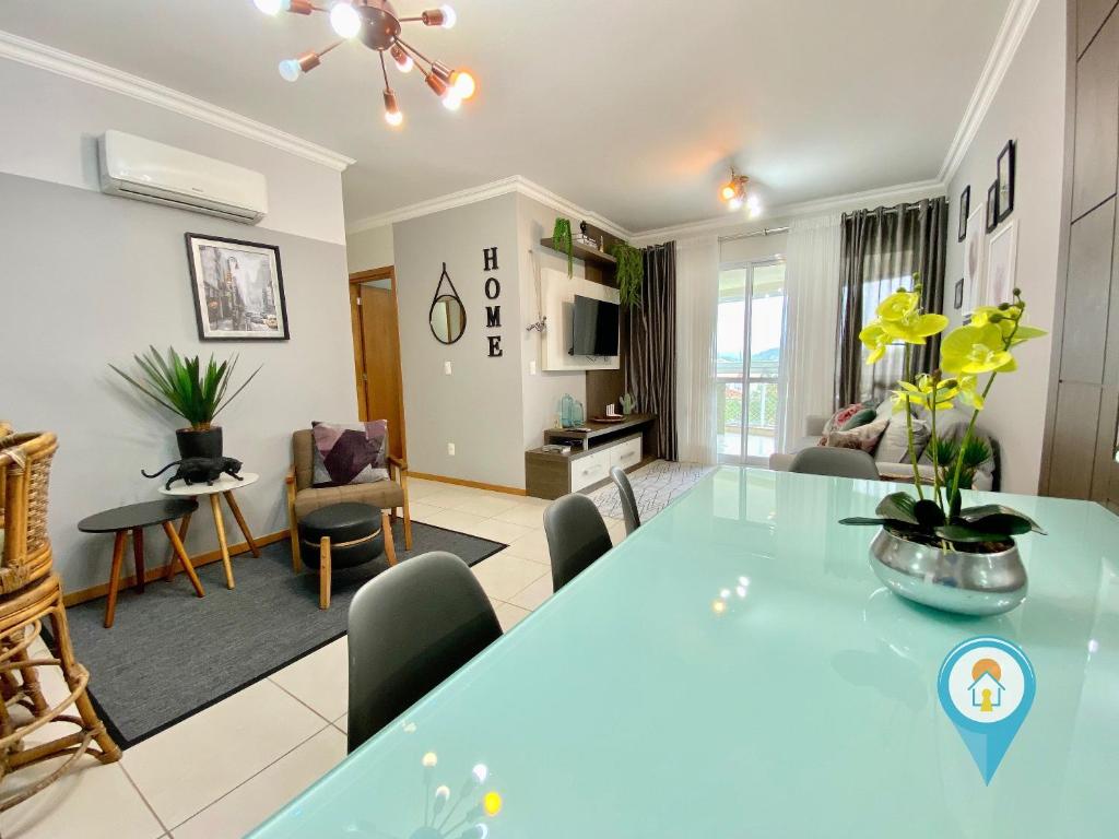 ein Wohnzimmer mit einem großen blauen Tisch und Stühlen in der Unterkunft Apto 3 Quartos em Home Club com telas de Proteção in Penha