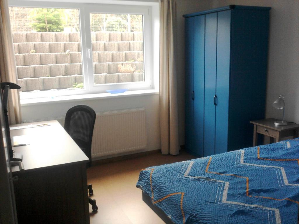 a bedroom with a bed and a desk and a window at "Libelle am Bernsteinsee" Zimmer in Stüde, Sassenburg in Sassenburg