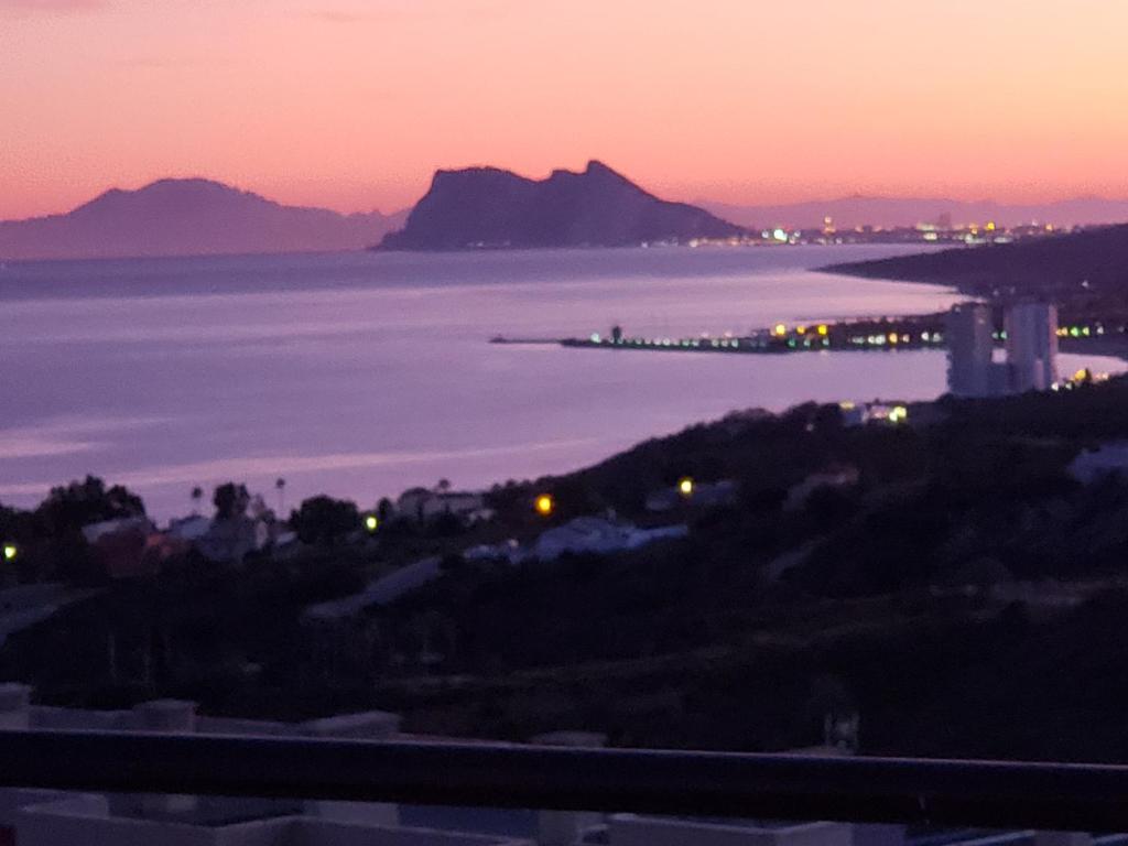 Manilva Townhouse with spectacular views of Gibraltar في مانيلفا: اطلالة على المحيط وقت الغروب