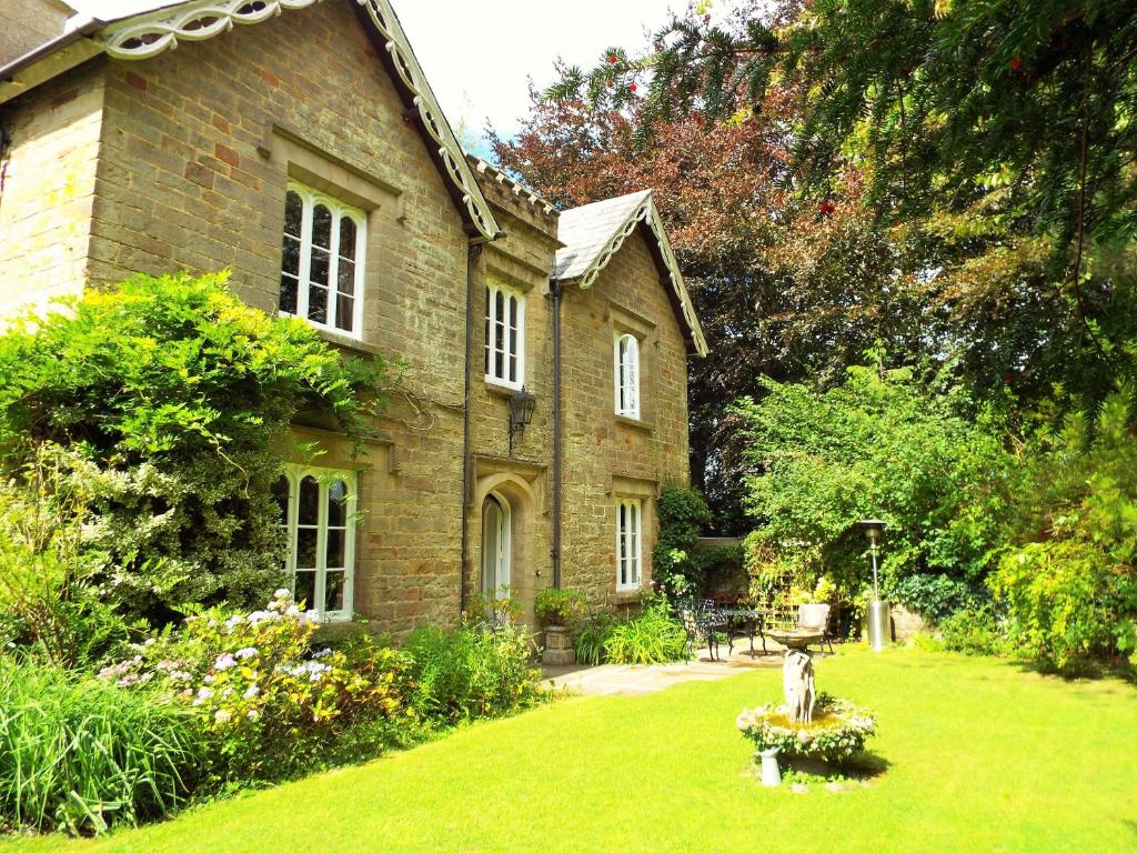 an old brick house with a garden in the yard at Old Vicarage B&B in Coleford