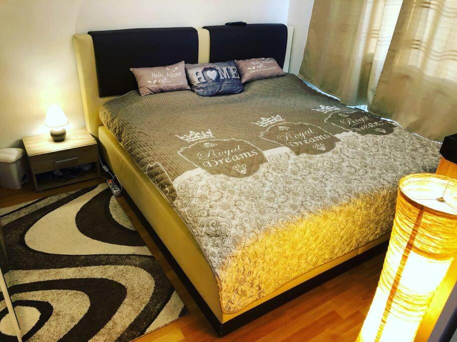 een slaapkamer met een bed met een deken en kussens bij Vasari Home in Meersburg