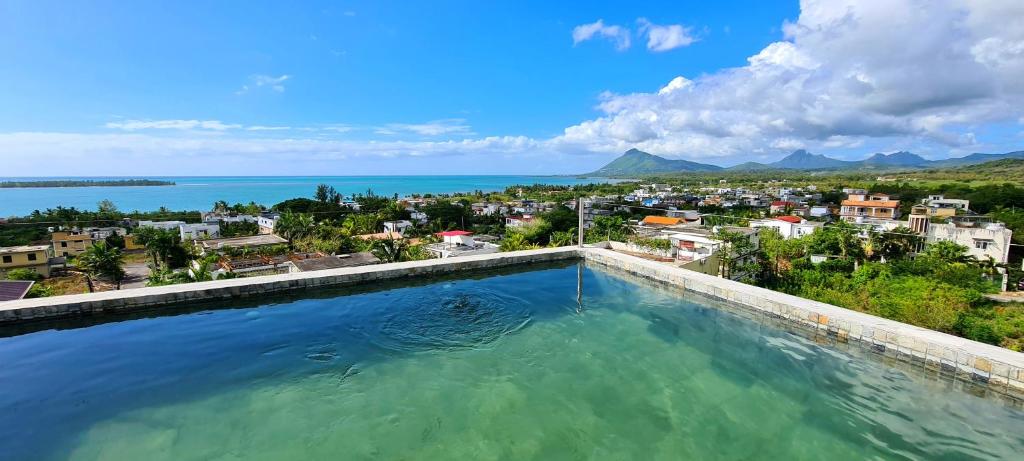 a swimming pool with a view of a city and the ocean at Laolabatwo in La Gaulette