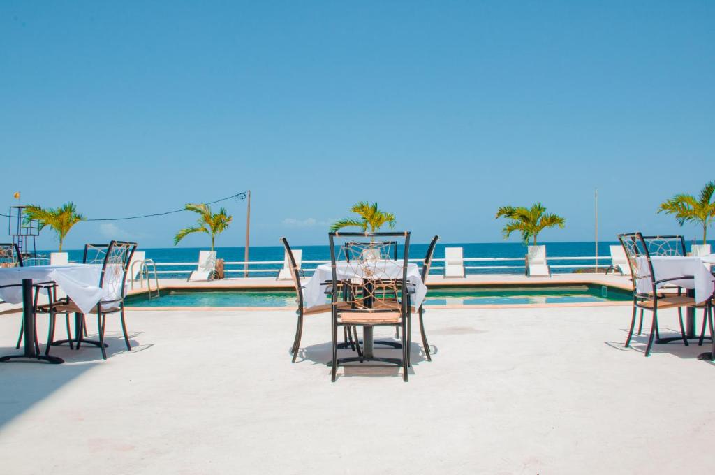 a table and chairs on a patio next to a pool at Falucho Paradise Beach in Pedra Badejo