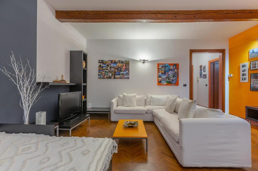 un soggiorno con divano bianco e TV di Central Ferrara Apartment a Ferrara
