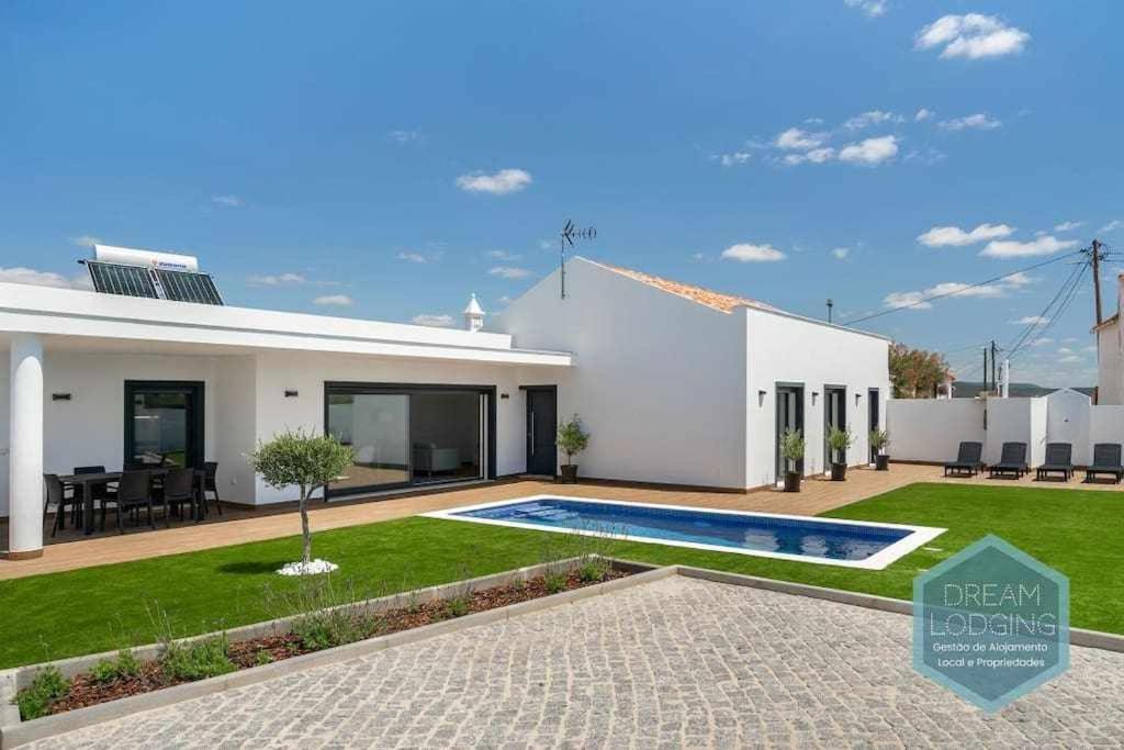 a white house with a swimming pool in a yard at Casa do Alto Dream Lodging in Albufeira