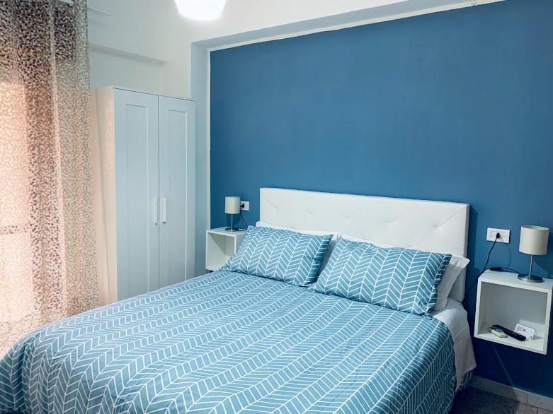 1 dormitorio azul con 1 cama con pared azul en B&B New Triscele, en Sciacca