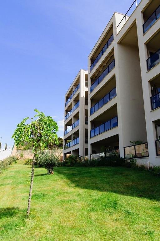 un grand bâtiment avec un arbre devant dans l'établissement T2 PORTICCIO AGOSTA PLAGE 100M DE LA PLAGE, à Porticcio