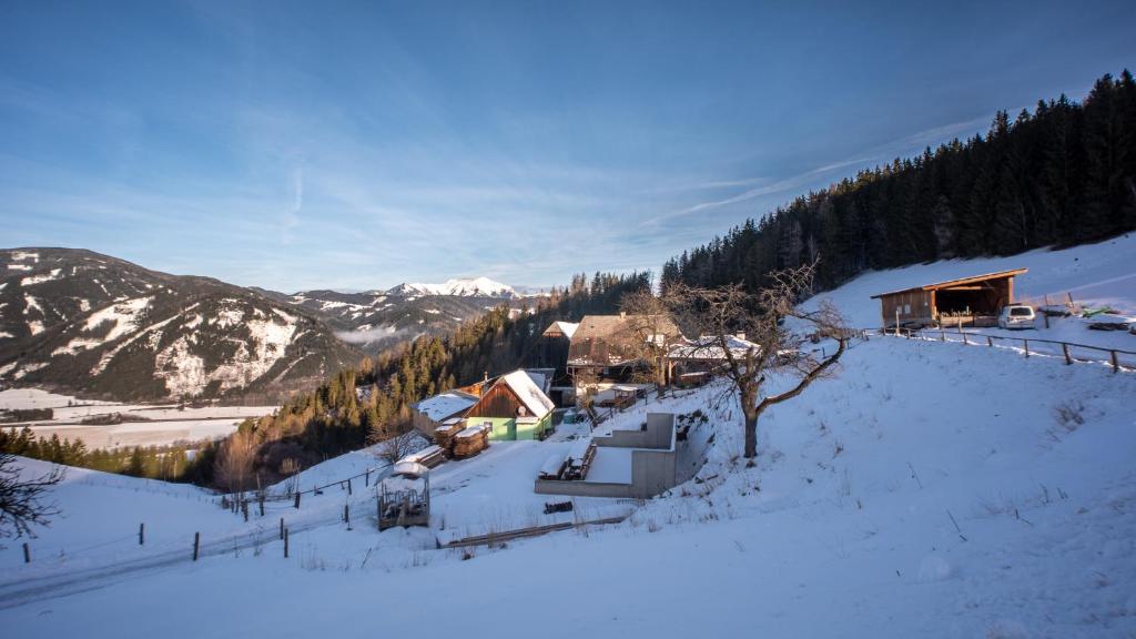 einen schneebedeckten Hügel mit einer Lodge in den Bergen in der Unterkunft BIO-Peisingerhof in Sankt Stefan ob Leoben