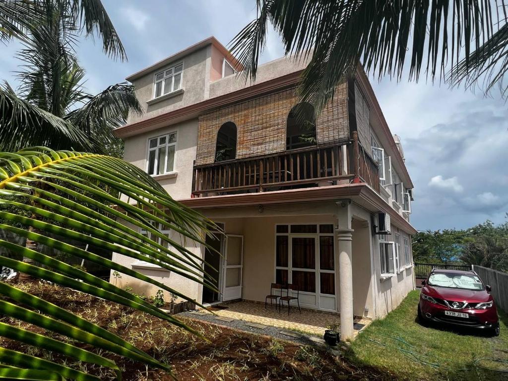 Suntoo Villa Wind & Kitesurf Accommodation في لا جاوليتي: منزل فيه سيارة حمراء متوقفة أمامه