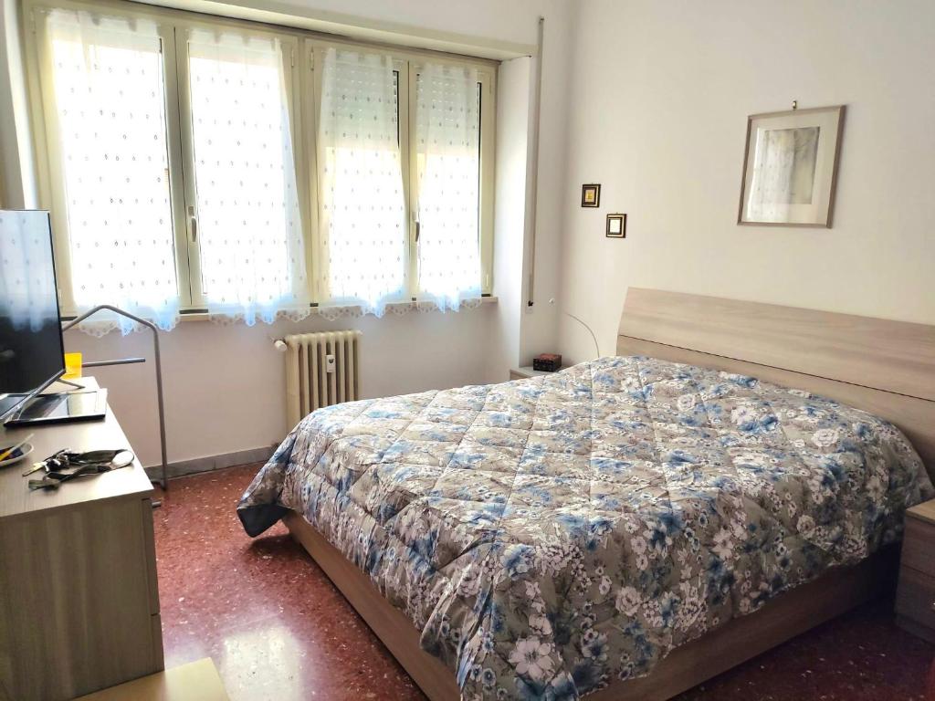 a bedroom with a bed and a desk and windows at Distretto 14 in Rome