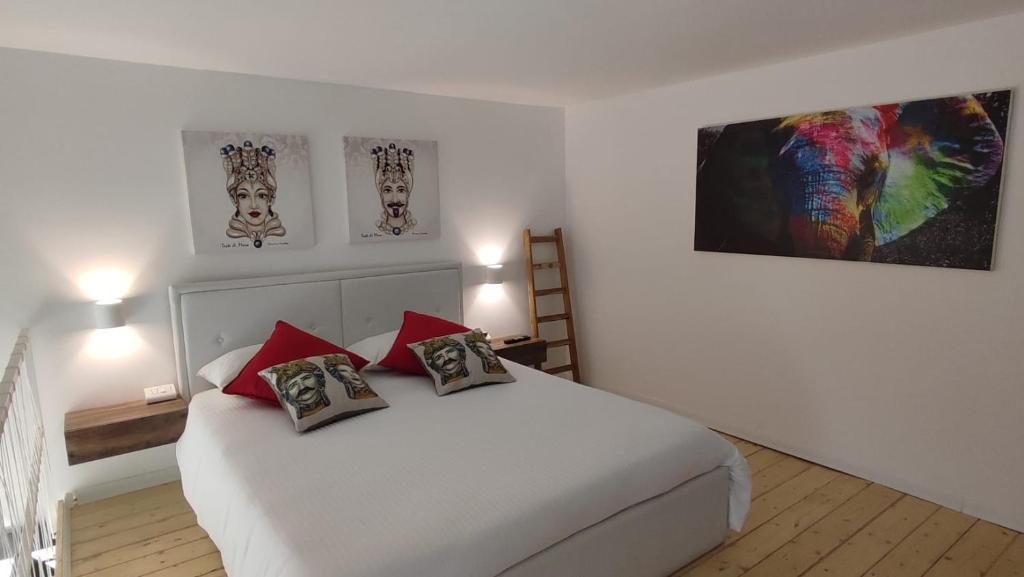 a bedroom with a white bed with red pillows at GH Rooms Catania in Catania